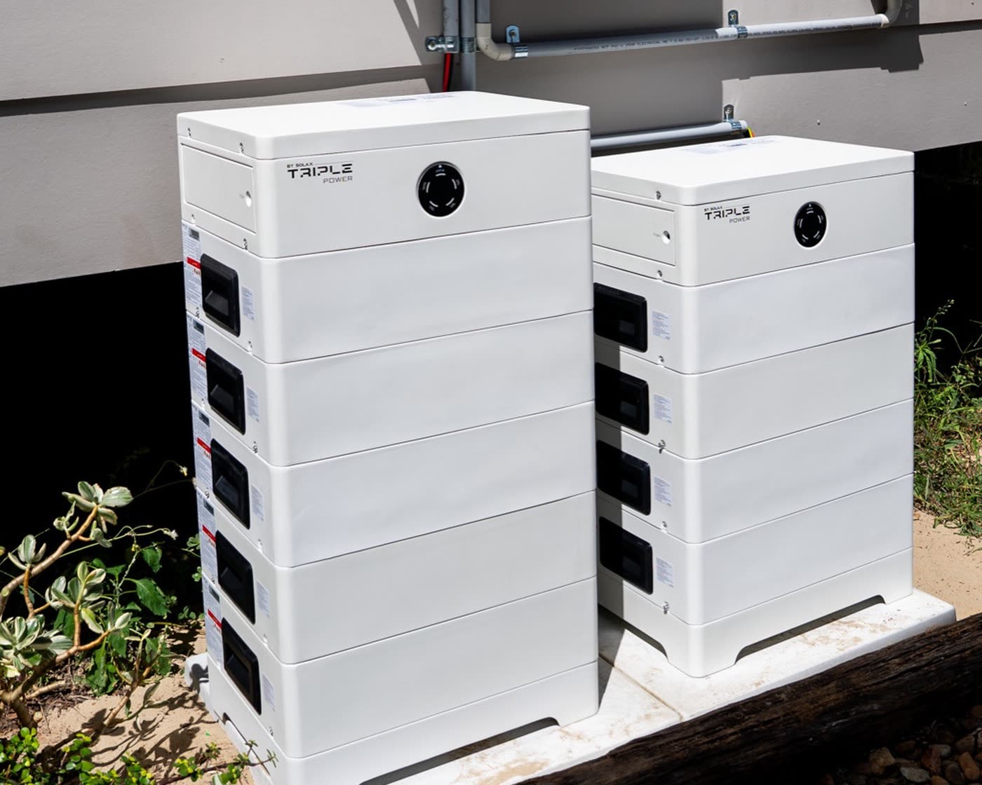 Two home battery storage units installed alongside a house